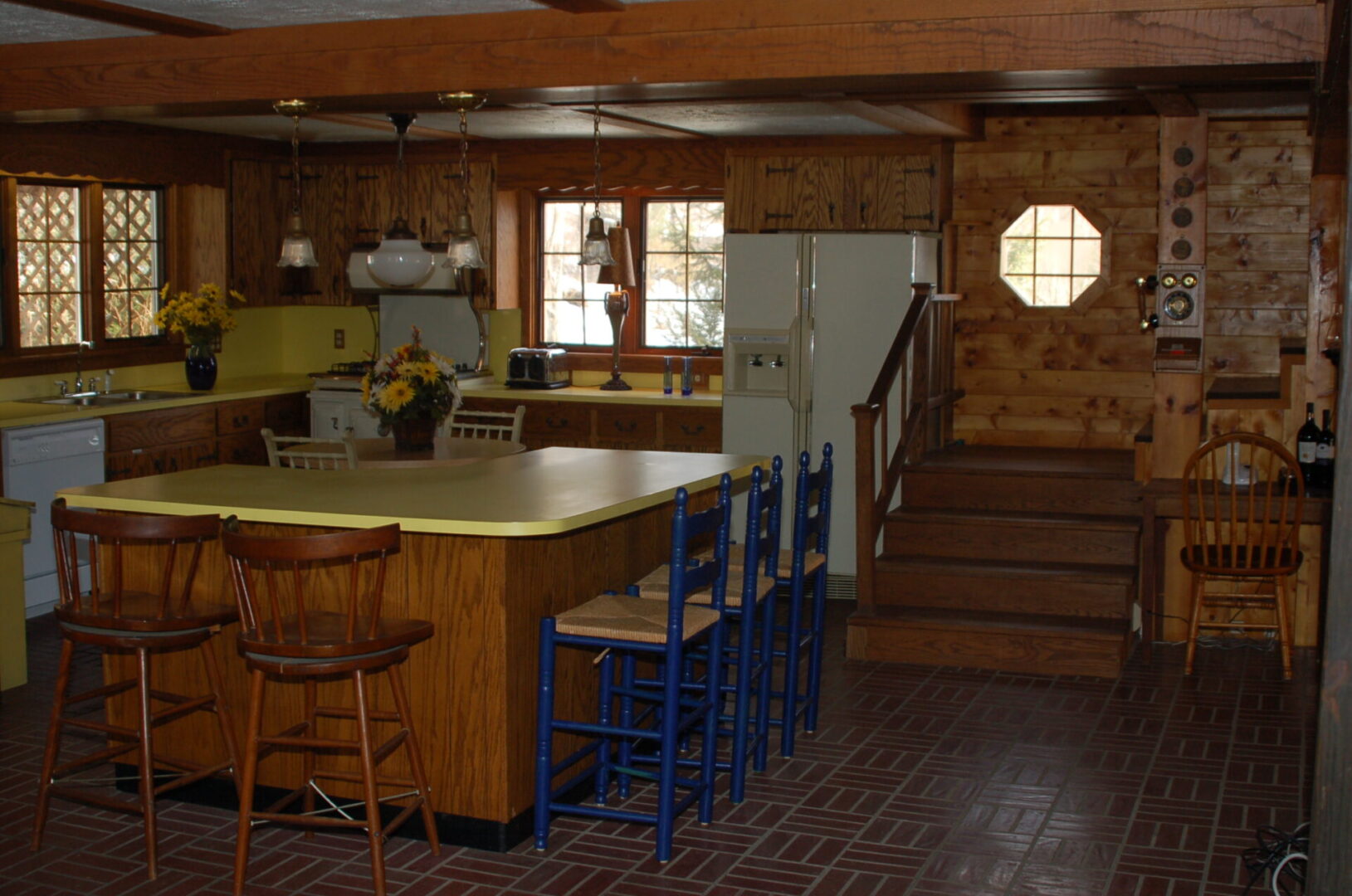 Kitchen island with four chairs and a staircase.