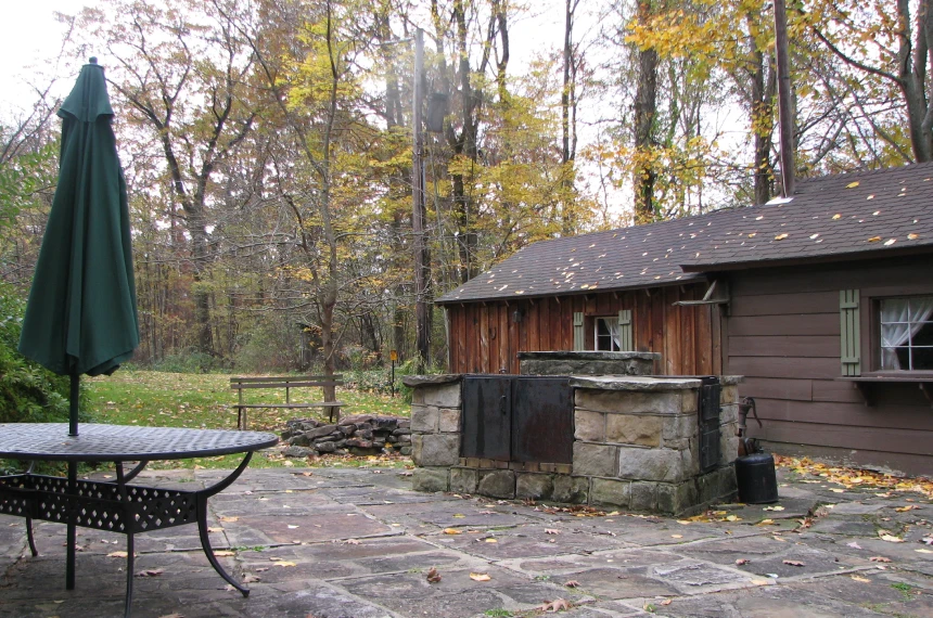 Stone patio with a wooden cabin in the background.