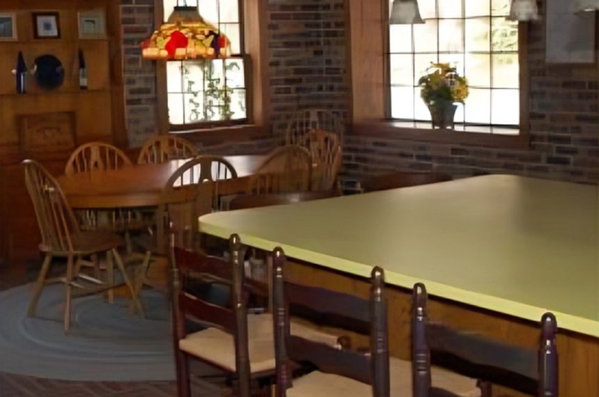 Large wooden table with chairs in a dining room.